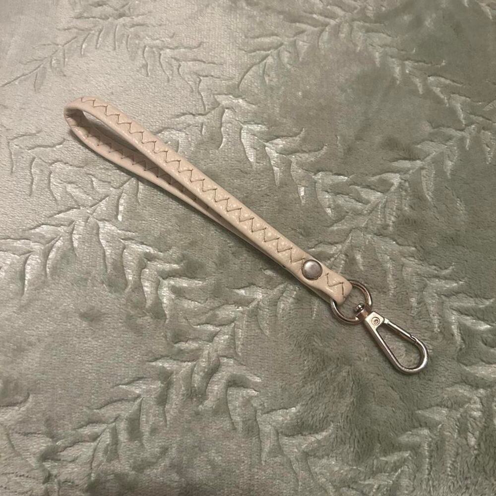 Cream wristlet with zigzag stitching